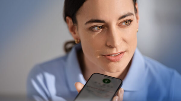 Frau spricht in ein Smartphone und nutzt dabei die mobile Spracherkennungslösung Voicepoint Xenon.