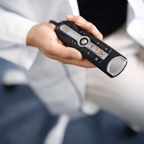 Eine Hand hält ein Diktiermikrofon, das zum Diktieren mit Voicepoint Helium verwendet wird.