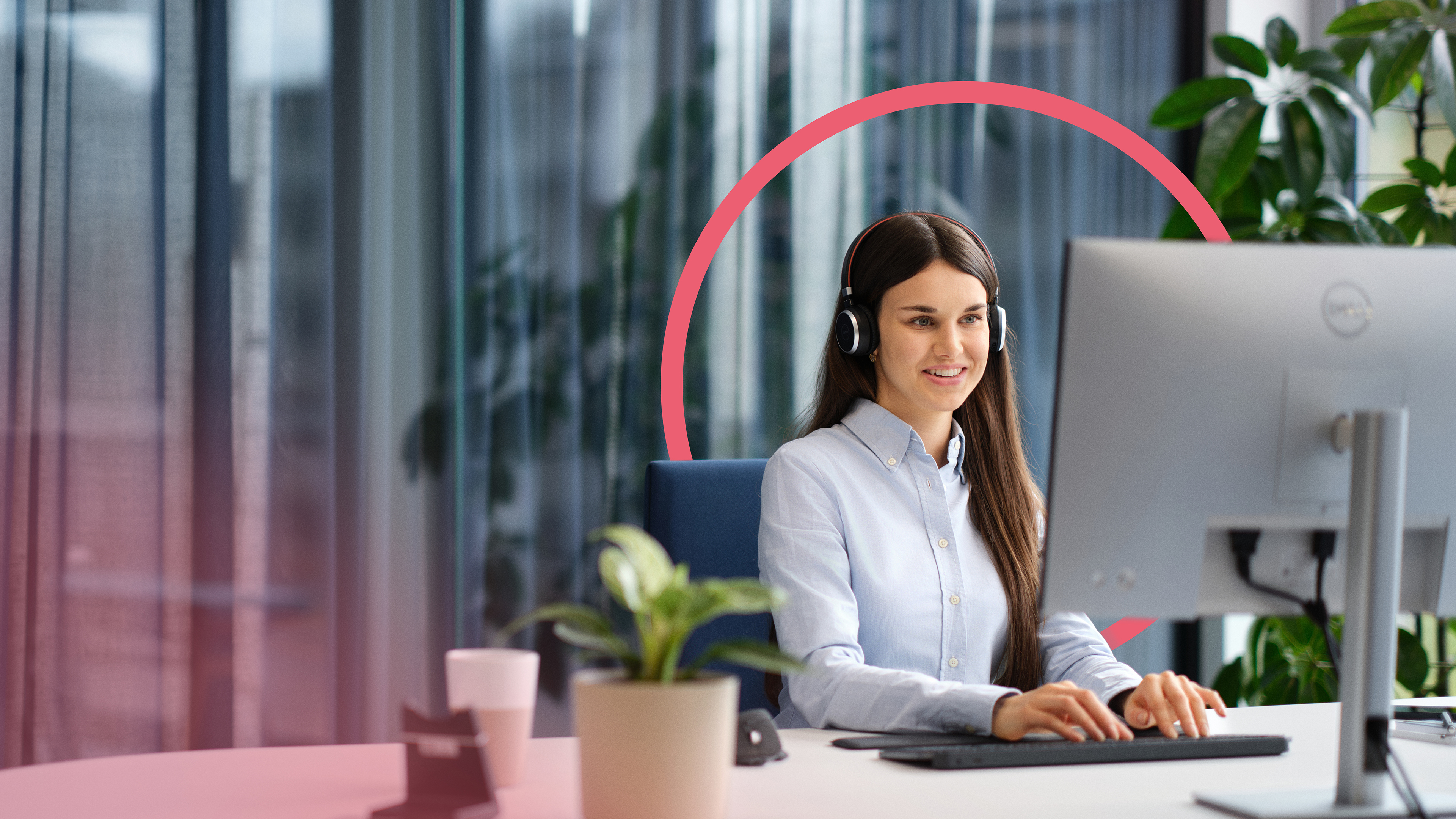 Eine Sekretärin transkribiert Berichte am Computer und trägt dabei ein Headset. Im Hintergrund ist ein pinker Kreis als Gestaltungselement zu sehen.