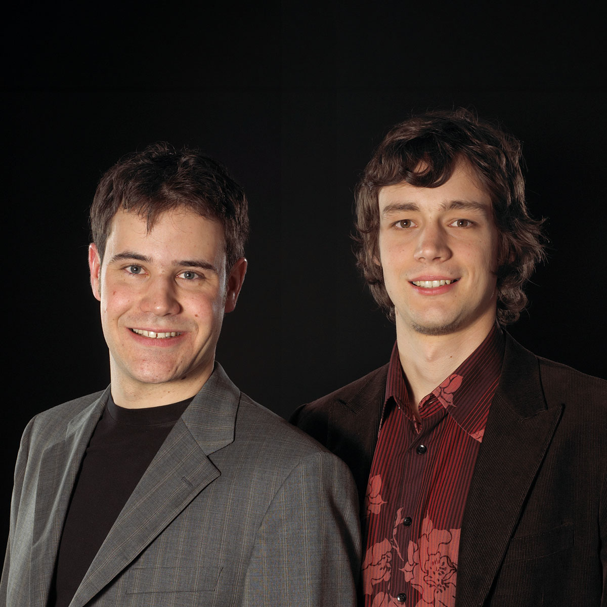 Bild von den beiden Gründern Reto Heusser (links) und Jonas Blum (rechts) vor einem dunklen Hintergrund.