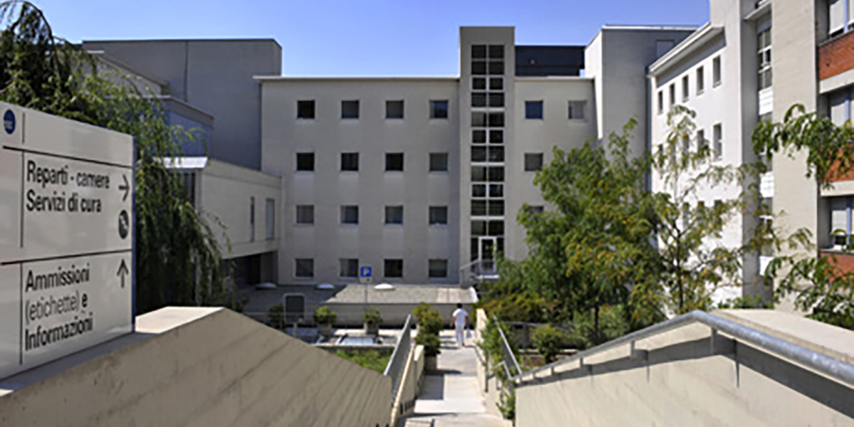 Bâtiment de l'Ente Ospedaliero Cantonale avec entrée et panneau indicateur au premier plan.