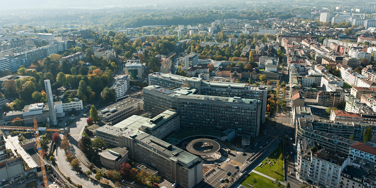 Luftaufnahme der Hôpitaux Universitaires de Genève mit dem grossen Krankenhauskomplex und der umliegenden Stadt.