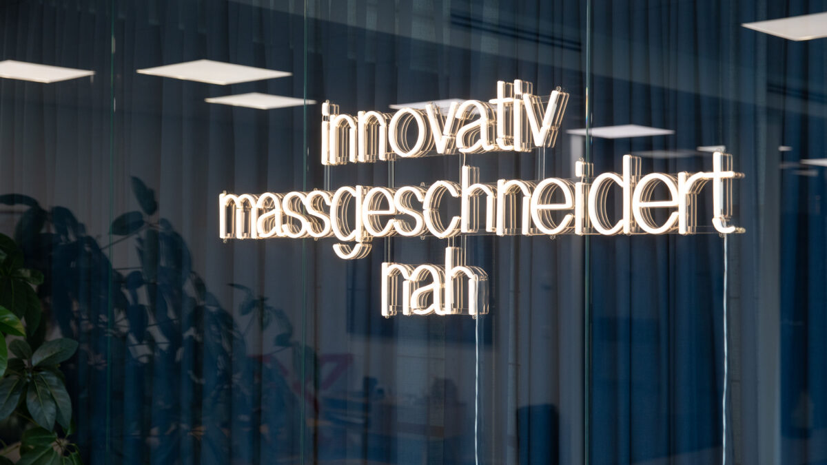 An einer Glaswand im Büro des Standorts Wetzikon hängt eine Leuchtschrift mit den Unternehmenswerten der Voicepoint AG: innovativ, massgeschneidert, nah.