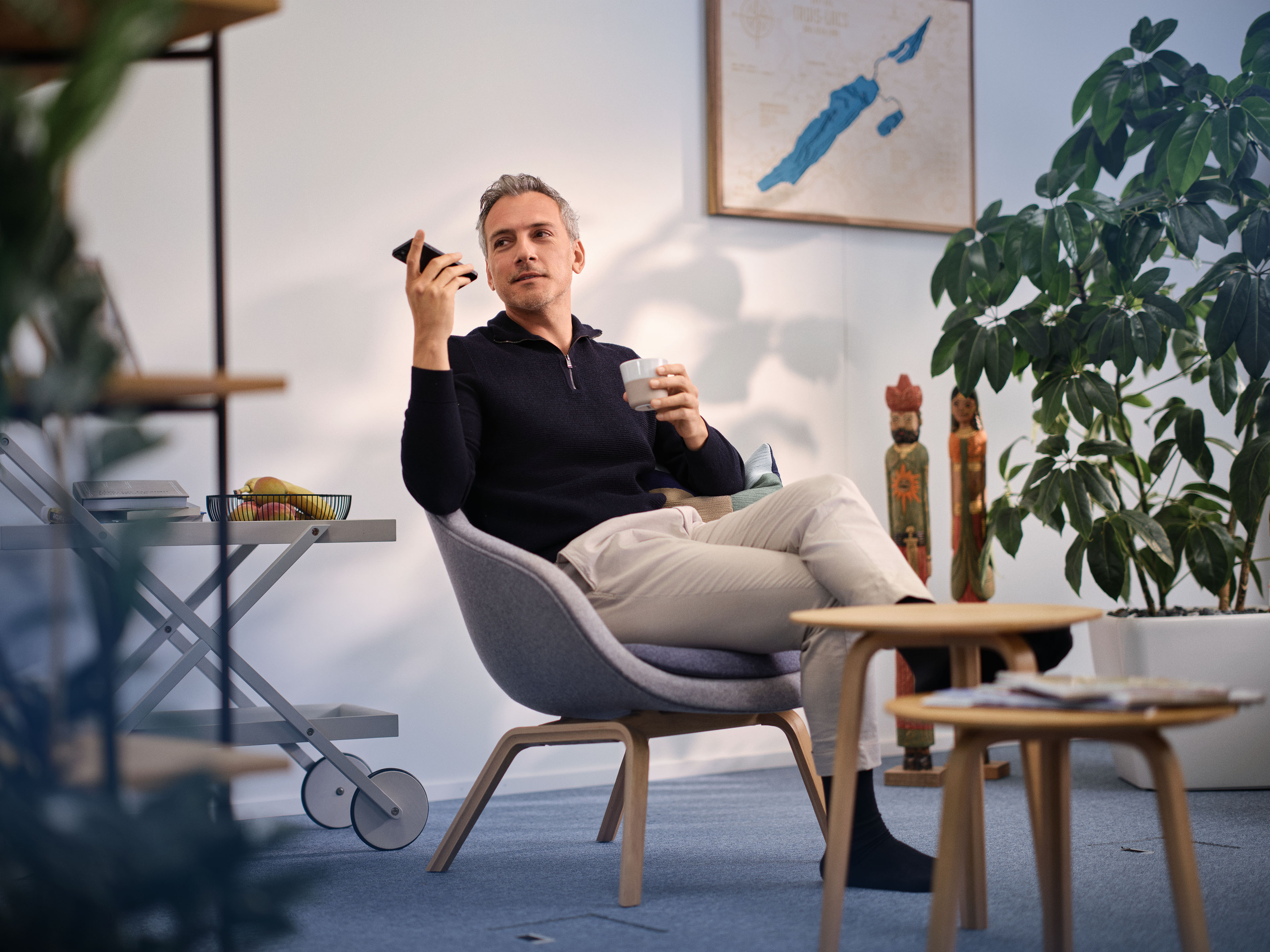 Mann sitzt zu Hause entspannt im Sessel und diktiert mit Voicepoint Xenon Dragon direkt mit dem Smartphone.